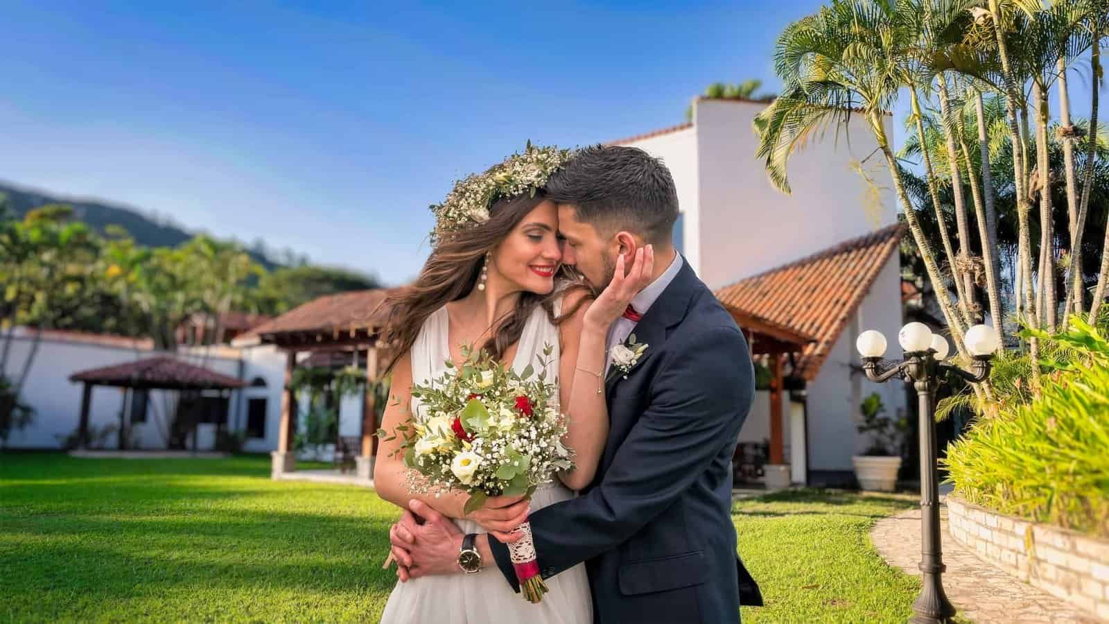 Your Dream Wedding in Paradise Bride and groom sharing intimate moment in tropical gardens with palm trees and mountain views at Ancestral Copán Hotel